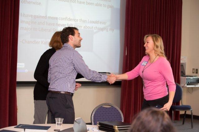 Presenter shaking hands during certificate presentation